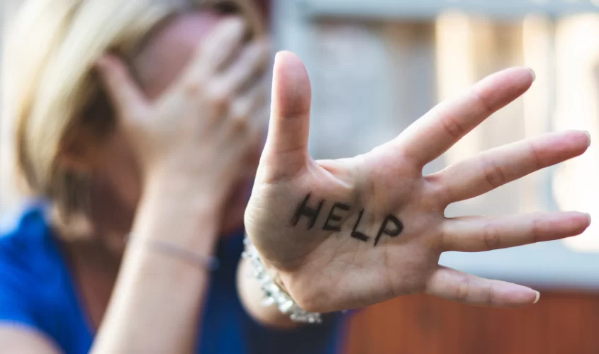Woman with hand out with the writing HELP on hand