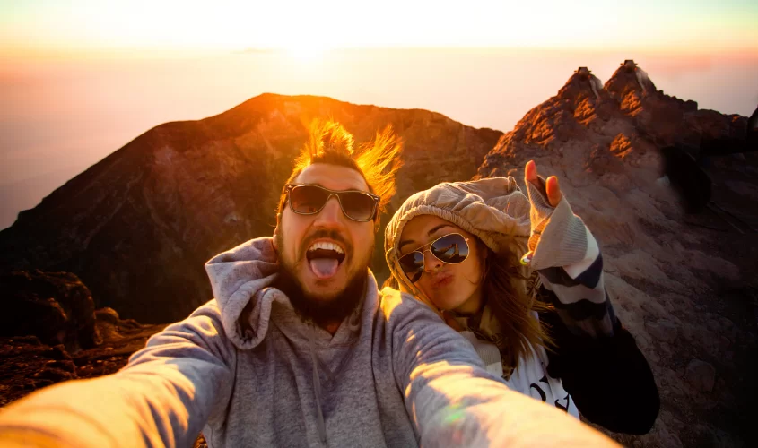 Couple taking picture on top of a mountain