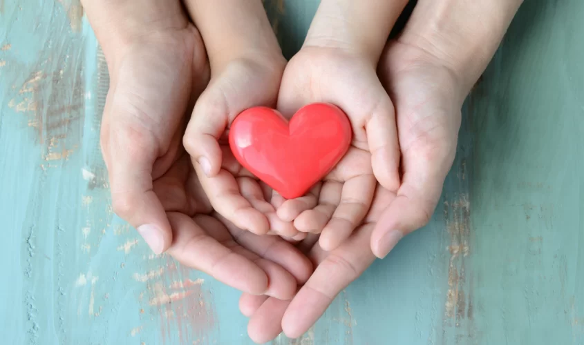 Parent and Child's hands with a heart in the centre