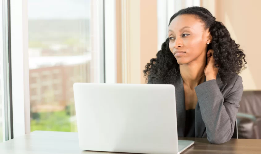 Woman looking out window with laptop open