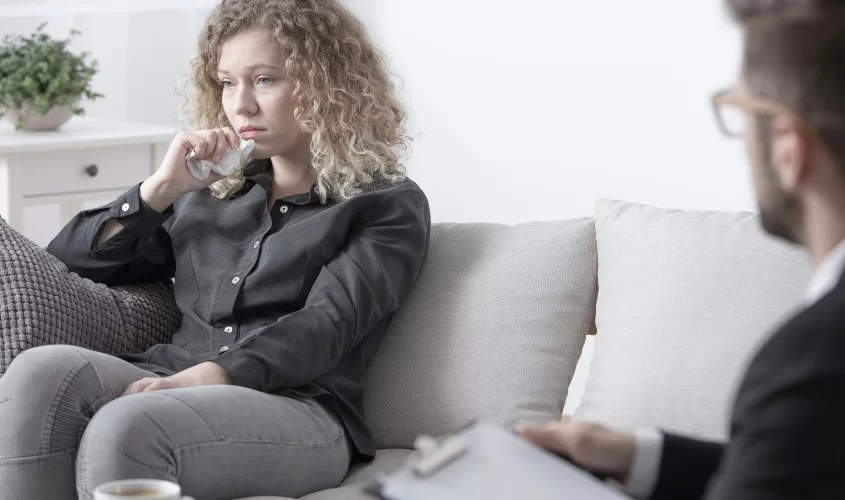 Woman upset sitting on couch in therapy