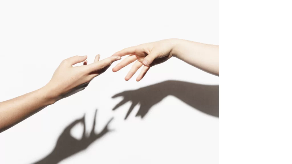 Two hands touching symbolizing togetherness.