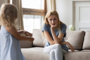 A child wanting to her mom who does not look impressed or want to
