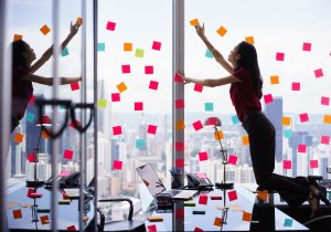 Female employee covering her work window with post-it notes