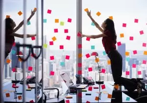 Female employee covering her work window with post-it notes