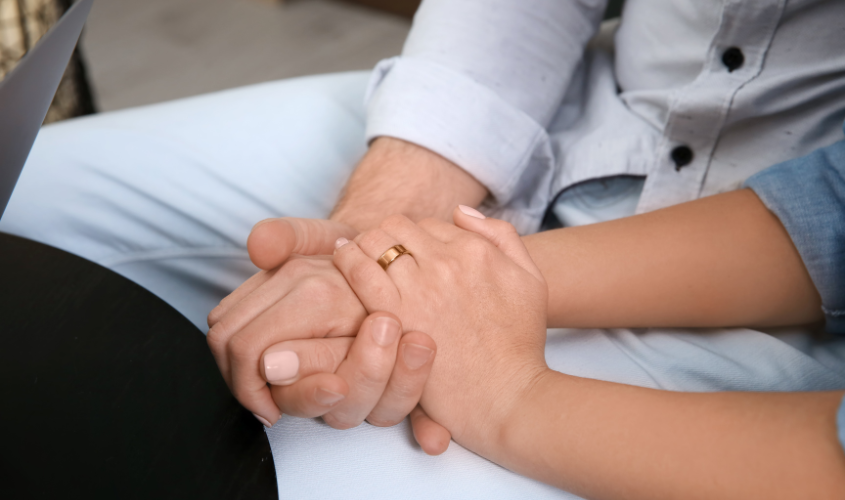 Couple holding hands in a sex therapy session.