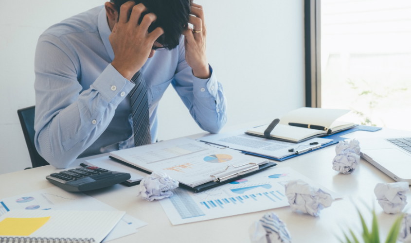 Worker struggling with stress at his desk.