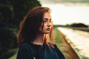 Day Dreaming Sad Looking Teenage Woman Outdoors in Sunset Twilight