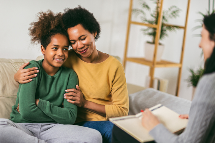 Mother and her teenager daughter talking with therapist.