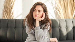 Women Sitting on a Black Couch Looking Upset