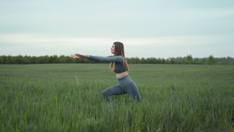 Woman practicing yoga in a green field, enjoying nature and freedom in Львів, Ukraine.